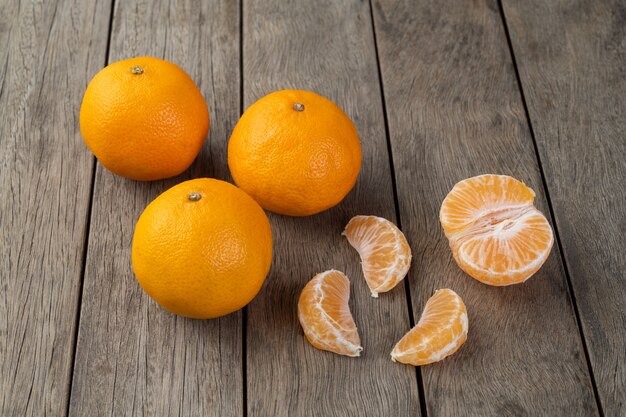 Mandarijnen met gesneden fruit over houten tafel.