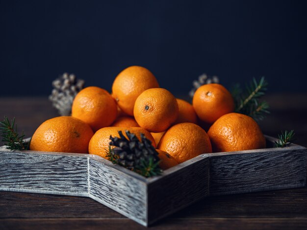 Mandarijnen met Kerstdecoratie op rustieke houten achtergrond. Mandarijnen met sparren. Kerst decoratie.