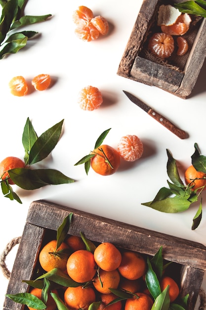 Foto mandarijnen met verse bladeren in houten kist geïsoleerd op wit, geïsoleerd op een witte, bovenaanzicht