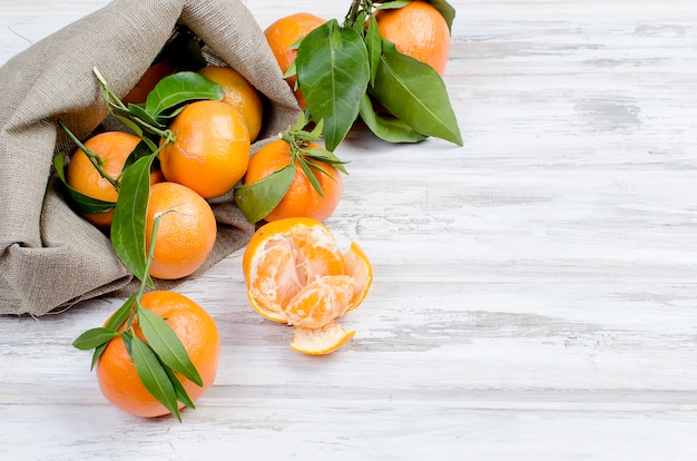 Mandarijnenclementine met bladeren op een houten lijst.