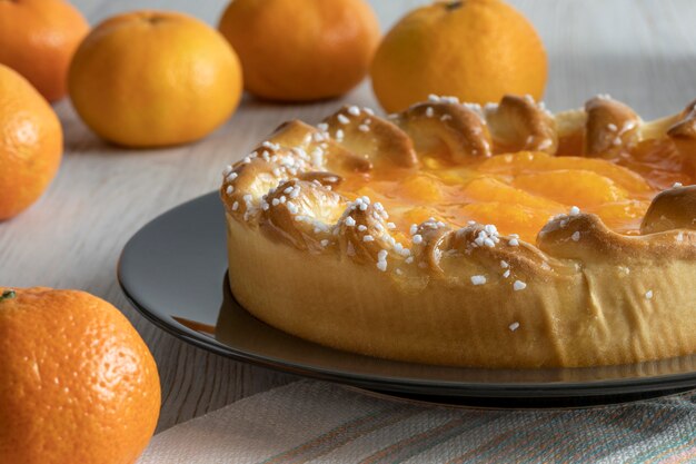 Mandarin cake and tangerines on rustic background, close-up