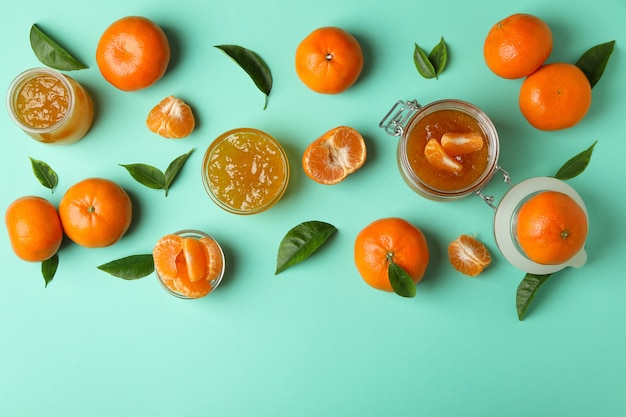 Mandarin jam and ingredients on mint background, top view
