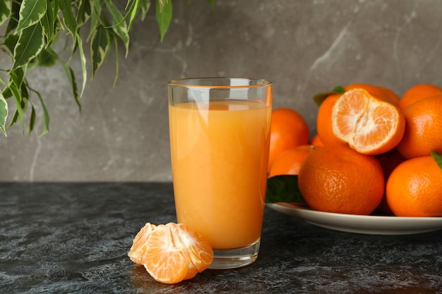 Mandarin juice and ingredients on black smokey table