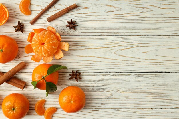 Mandarins and cinnamon on white wooden background