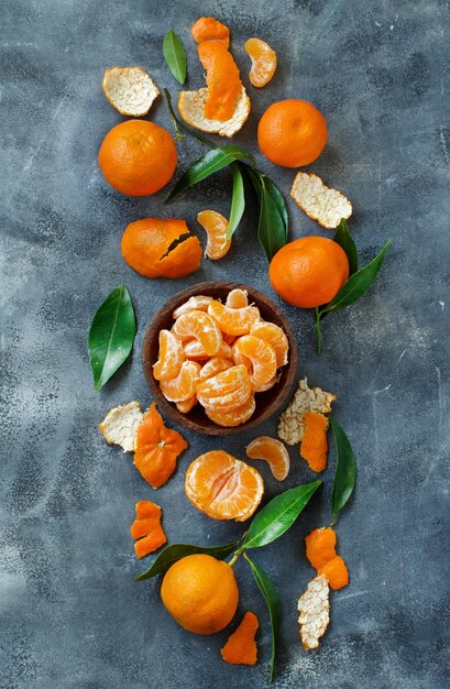 Mandarins with leaves in a bowl on a grey  background