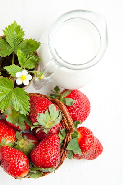 Mandje met verse aardbeien en melk