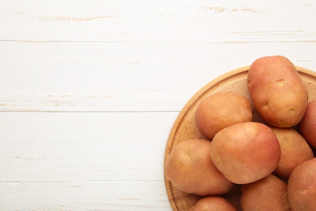 Mandje van verse, smakelijke nieuwe aardappelen op witte achtergrond. Bovenaanzicht