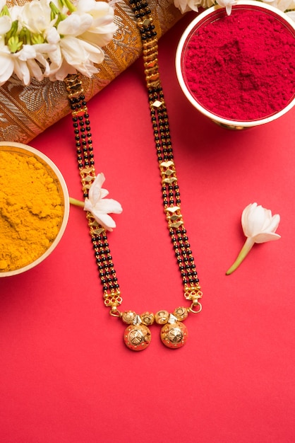Мангалсутра или Золотое ожерелье для замужних индуистских женщин, украшенное традиционным сари с хульди кумкум и цветами могры гаджра, выборочный фокус