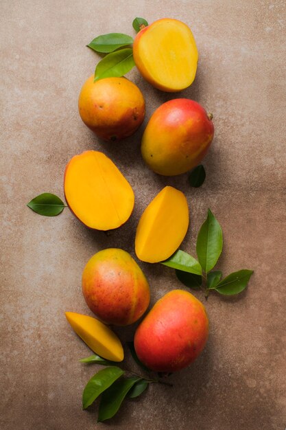 Mango achtergrond ontwerpconcept Bovenaanzicht van verse mango fruit patroon met bladeren op tafel