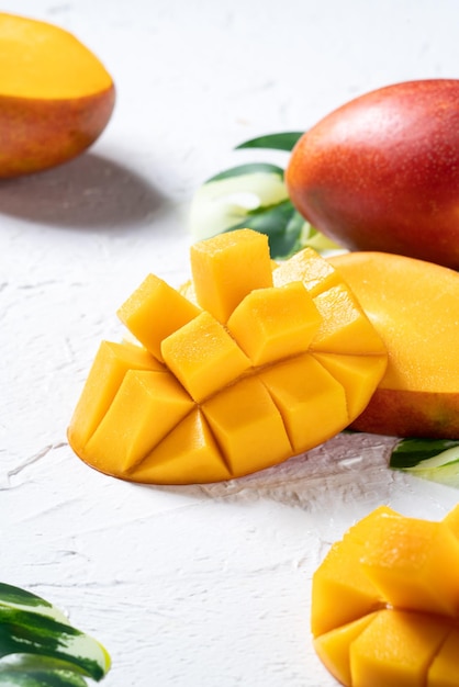 マンゴーの背景デザインコンセプト上面図白いテーブルにさいの目に切った新鮮なマンゴーフルーツ