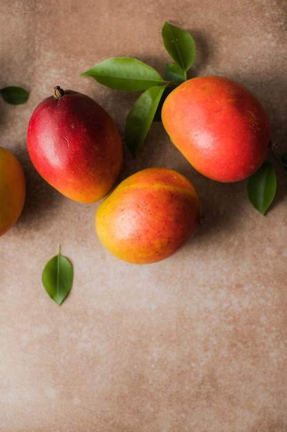 Mango background design concept Top view of fresh mango fruit pattern with leaves on table