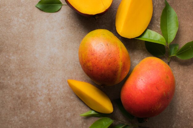 Mango background design concept Top view of fresh mango fruit pattern with leaves on table