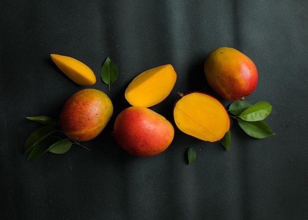 Mango background design concept Top view of fresh mango fruit pattern with leaves on table