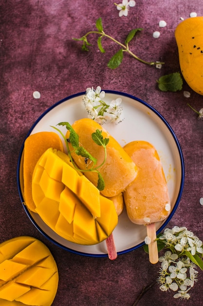 Mango banaan ijslolly's met vers fruit plat bovenaanzicht