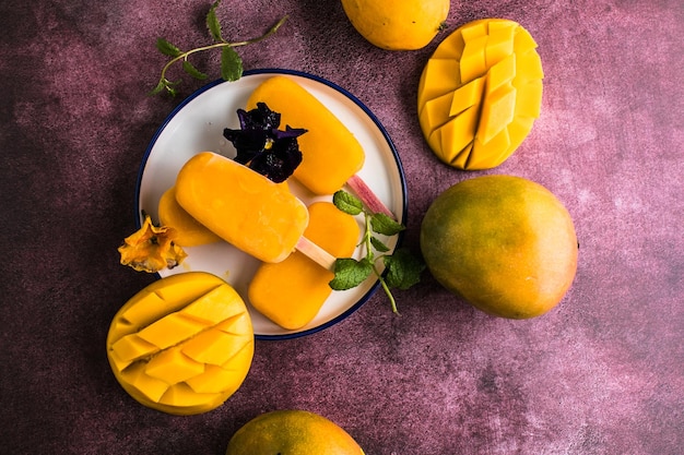 Mango banana popsicles with fresh fruits flat lay top view