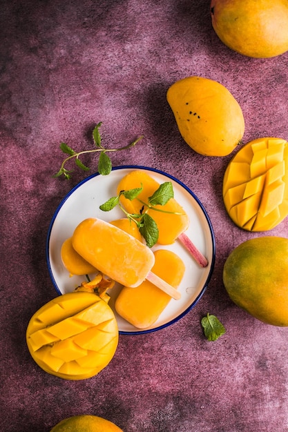 Mango banana popsicles with fresh fruits flat lay top view