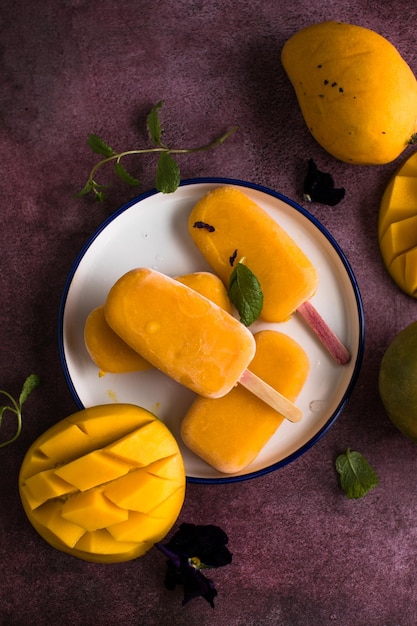 Mango banana popsicles with fresh fruits flat lay top view