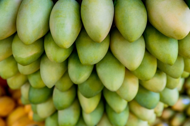 Stand del festival del mango con frutti di mango gialli freschi nel fuoco selettivo del mercato di strada