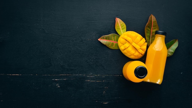 Mango and fresh juice on a black wooden background Tropical Fruits Top view free space for your text