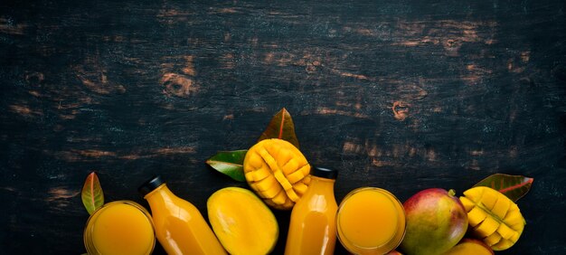 Mango and fresh juice on a black wooden background Tropical Fruits Top view free space for your text