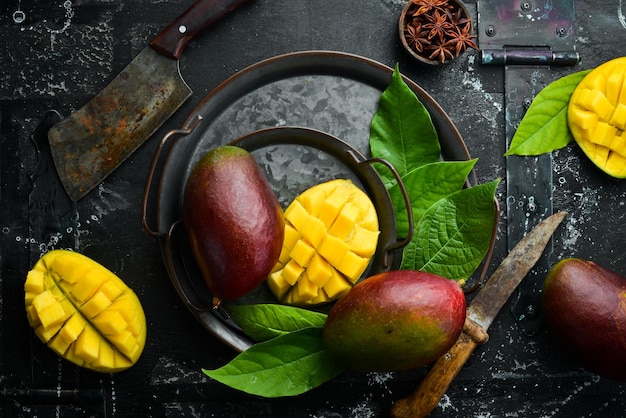 Манго Свежее сочное спелое манго, нарезанное ломтиками на тарелке Тропические фрукты Вид сверху с копией пространства