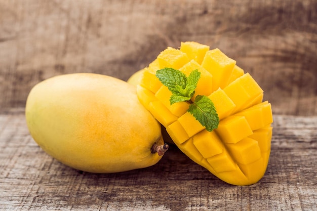 Mango fruit and mango cubes on the wooden table