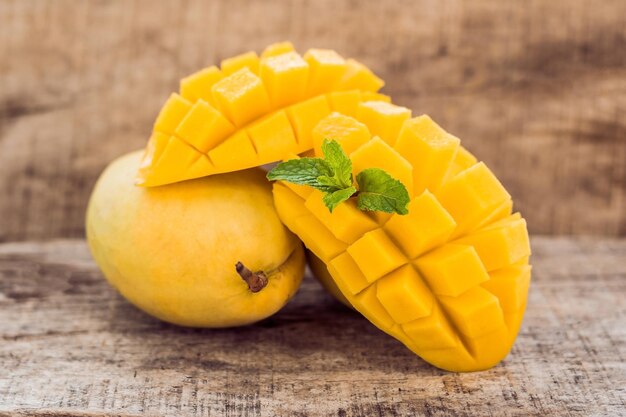 Mango fruit and mango cubes on the wooden table