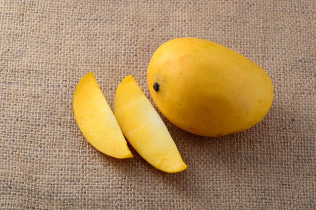 Mango fruit with slice on sack cloth background