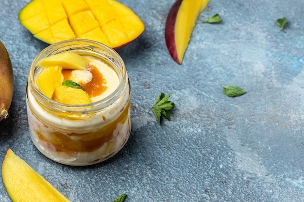Mango ice cream or sorbet in jar homemade fruit mango ice cream on blue background italian dessert gelato