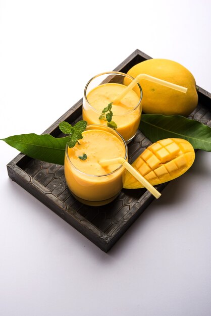 Mango Lassi of yoghurt, Indiase populaire zomerdrank geserveerd in glas met heel Alphonso Aam-fruit, selectieve focus