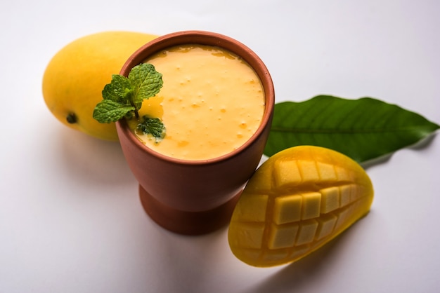 Mango Lassi of yoghurt, Indiase populaire zomerdrank geserveerd in glas met heel Alphonso Aam-fruit, selectieve focus