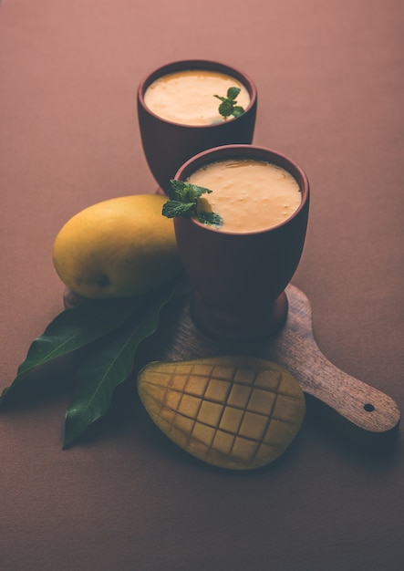 Mango Lassi of yoghurt, Indiase populaire zomerdrank geserveerd in glas met heel Alphonso Aam-fruit, selectieve focus