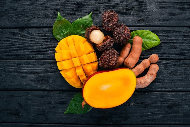 Mango rambutan and tamarind Fresh Tropical Fruits On a wooden background Top view Copy space