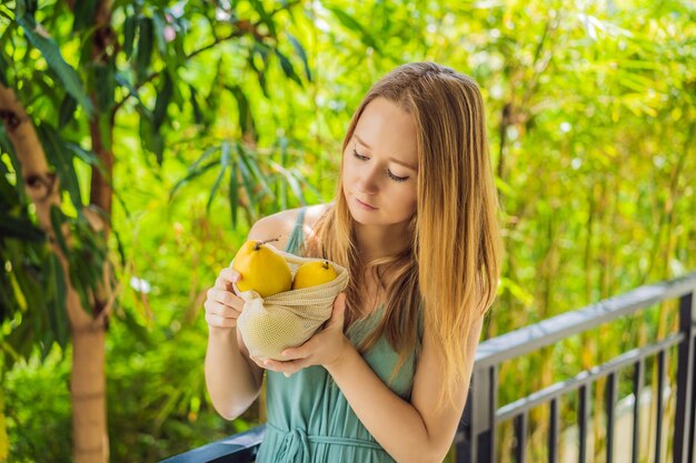 Mango in a reusable bag in female hands zero waste concept plastic free concept healthy clean eating