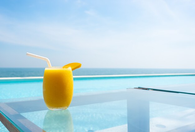 Frullati di mango con piscina e spiaggia del mare