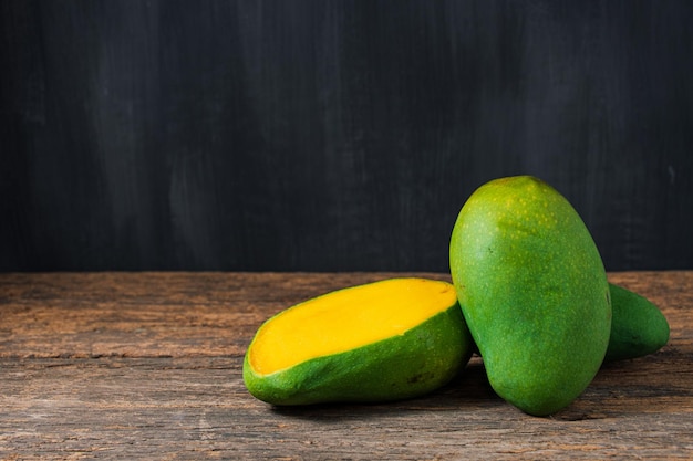 Mango tropical fruit on dark brown wooden table background copyspace for text