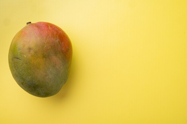 Mango whole fruit set, on yellow textured summer background, top view flat lay, with copy space for text