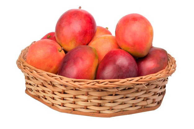 Mangoes in wicker basket on white background