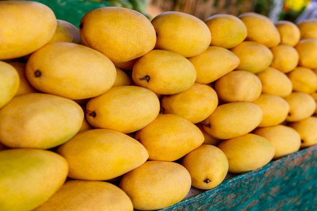 Foto mangofestivalstand met verse gele mangovruchten in de selectieve aandacht van de straatmarkt