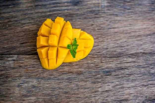 Foto mangofruit en mangoblokjes op de houten lijst.