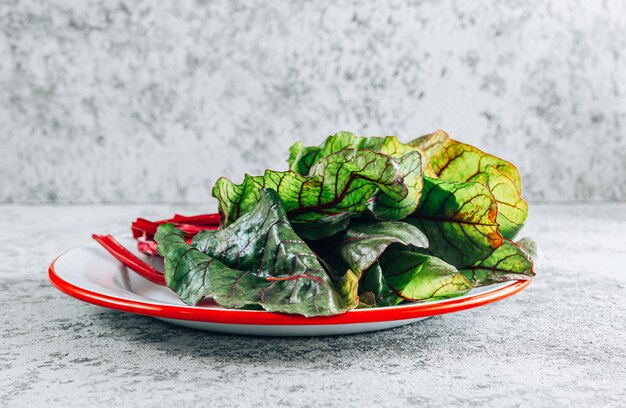 Foto insalata di mangold foglie fresche crude di bietole su uno sfondo di pietra