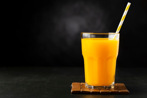 Mangosap in glazen beker op tafel Mango-smoothie