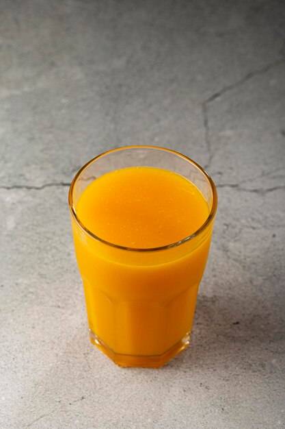 Mangosap in glazen beker op tafel Mango-smoothie