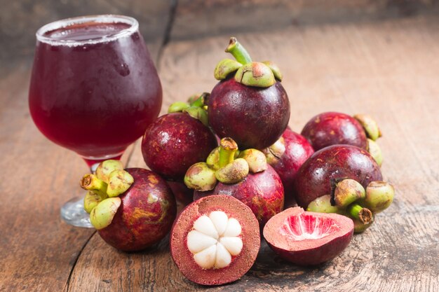 Mangostan en sap Vers uit de tuin op houten tafel