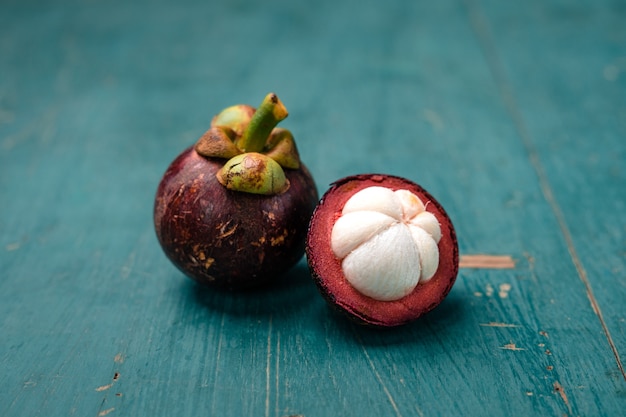 Frutto di mangostano su fondo di legno azzurro, frutta tropicale