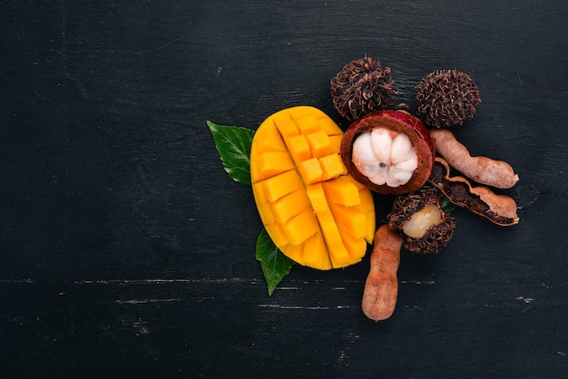 Mangosteen mango tamarinde en ramboetan vers tropisch fruit op een houten achtergrond Bovenaanzicht kopie ruimte