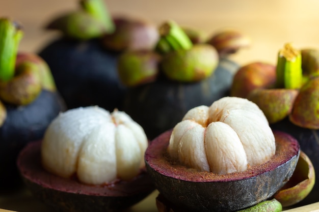 Foto mangosteen werd gepeld in een bord op een houten tafel.