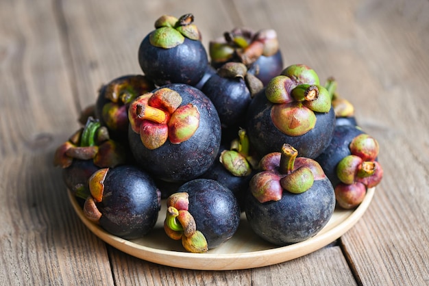 Mangosteen on wooden plate background fresh ripe mangosteen from tree at tropical fruit Thailand in summer