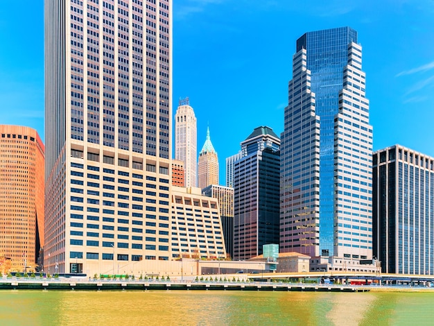 Manhattan downtown over East River with urban skyscrapers and blue sky in New York City, USA