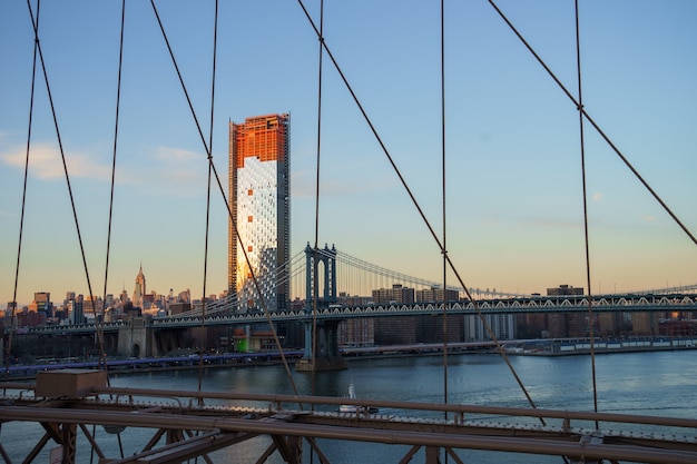 Manhattan Downtown skyline panorama with manhattan bridge foreground from Brooklyn Bridge Park riverbank, New York City, USA